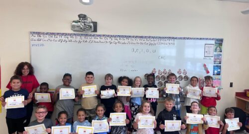 Group photo of Mrs. Relic's class holding their Zearn certificates in the classroom